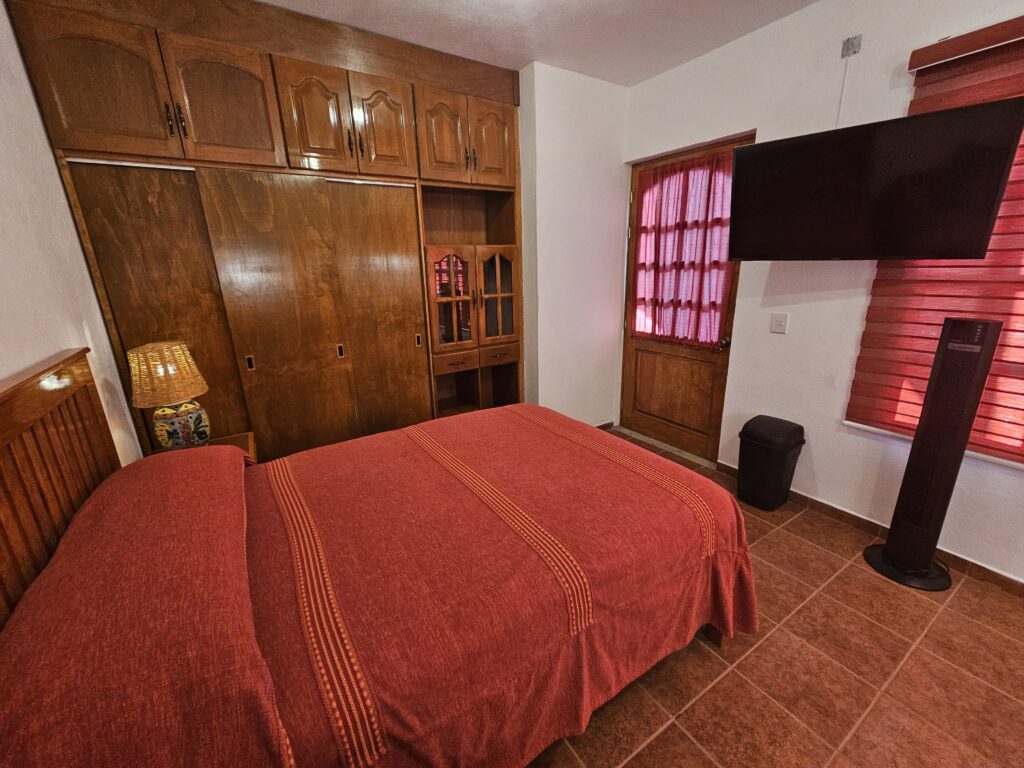 Fully furnished cozy bedroom featuring Smart TV and Tower Fan.